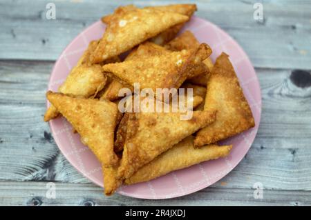 Una samosa Singara, una pasta fritta dell'Asia del Sud con un ripieno saporito che include ingredienti come patate speziate, cipolle, piselli, carne o pesce, sambousek Foto Stock