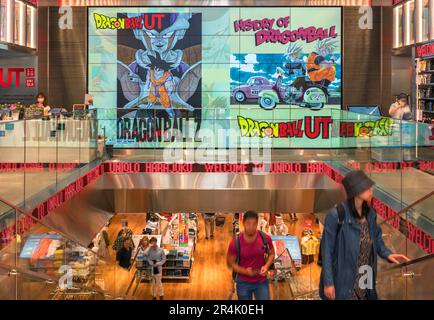 tokyo, harajuku - Maggio 10 2023: Vista interna di un negozio giapponese Uniqlo con una parete coperta da un grande schermo di opere d'arte pubblicitaria che presentano il popolare Foto Stock