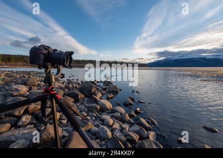 Tramonto su uno splendido lago calmo in Canada con fotocamera su cavalletto, scattare foto. Foto Stock