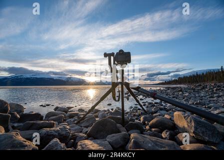 Tramonto su uno splendido lago calmo in Canada con fotocamera su cavalletto, scattare foto. Foto Stock