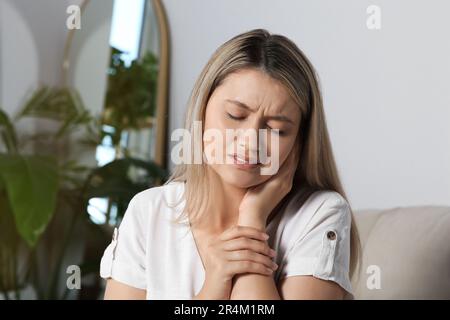 Giovane donna che soffre di dolore all'orecchio a casa Foto Stock