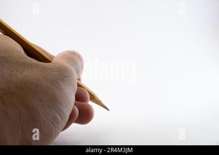 Mano isolata che tiene una matita su sfondo bianco Foto Stock