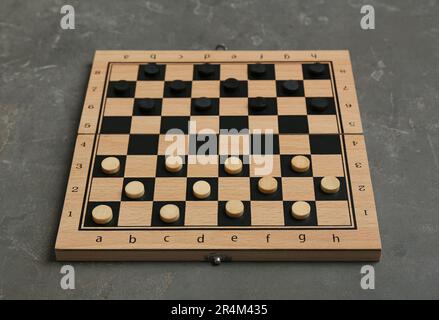 Scacchiera in legno con pedine sul tavolo grigio Foto Stock