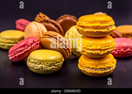 Macarons colorato sfondo nero Foto Stock