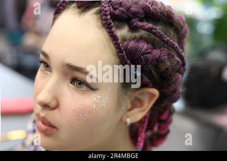 ragazza con capelli castani e pigtail intrecciati con capelli artificiali intrecciato. Foto Stock