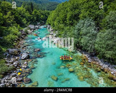 Valle Soca, Slovenia - veduta aerea del fiume alpino smeraldo Soca con barche da rafting che scendono lungo il fiume in una giornata estiva di sole Foto Stock