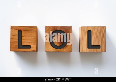 Parola LOL o ridere fuori forte su fondo cubo di legno. Foto Stock