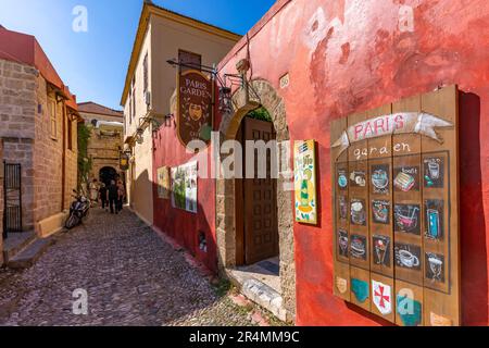 Vista del bar colorato in una stretta strada acciottolata, la città vecchia di Rodi, patrimonio dell'umanità dell'UNESCO, Rodi, Dodecanesi, Isole greche, Grecia, Europa Foto Stock