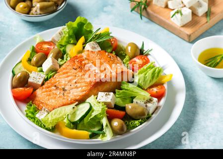 Filetto di salmone alla griglia e insalata di verdure fresche con pomodoro, olive, lattuga, formaggio feta. Keto mediterraneo - insalata greca e salma arrosto Foto Stock