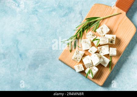 Formaggio Feta greco fresco. Ingrediente sano per cucinare insalata. Feta di capra tritata con erbe di rosmarino, spazio copia. Foto Stock