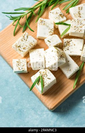 Formaggio Feta greco fresco. Ingrediente sano fatto in casa per cucinare insalata. Formaggio feta di capra tritato con erbe di rosmarino da vicino. Foto Stock