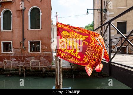 Bandiera veneziana che sventola su un canale a Venezia Foto Stock