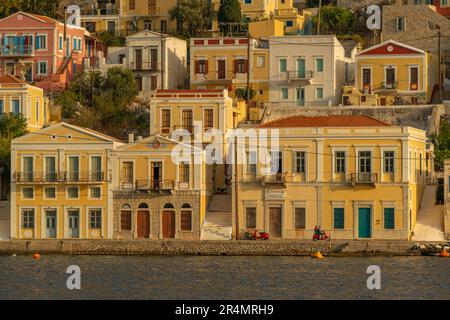 Vista degli edifici colorati che allineano il porto di Symi Town, Symi Island, Dodecaneso, Isole greche, Grecia, Europa Foto Stock