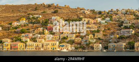 Vista degli edifici colorati che allineano il porto di Symi Town, Symi Island, Dodecaneso, Isole greche, Grecia, Europa Foto Stock