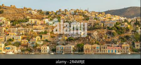 Vista degli edifici colorati che allineano il porto di Symi Town, Symi Island, Dodecaneso, Isole greche, Grecia, Europa Foto Stock