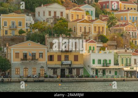 Vista degli edifici colorati che allineano il porto di Symi Town, Symi Island, Dodecaneso, Isole greche, Grecia, Europa Foto Stock