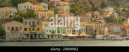 Vista degli edifici colorati che allineano il porto di Symi Town, Symi Island, Dodecaneso, Isole greche, Grecia, Europa Foto Stock