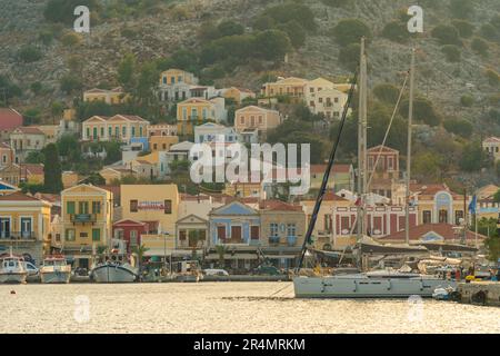 Vista degli edifici colorati che allineano il porto di Symi Town, Symi Island, Dodecaneso, Isole greche, Grecia, Europa Foto Stock