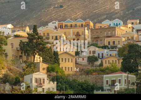 Vista degli edifici colorati che allineano il porto di Symi Town, Symi Island, Dodecaneso, Isole greche, Grecia, Europa Foto Stock