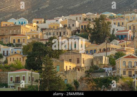 Vista degli edifici colorati che allineano il porto di Symi Town, Symi Island, Dodecaneso, Isole greche, Grecia, Europa Foto Stock