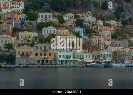 Vista degli edifici colorati che allineano il porto di Symi Town, Symi Island, Dodecaneso, Isole greche, Grecia, Europa Foto Stock