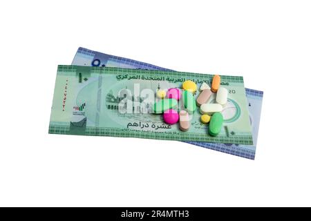 Concetto di costo medico e sanitario con pillole sugli Emirati Arabi Uniti nuove banconote isolate su sfondo bianco Foto Stock