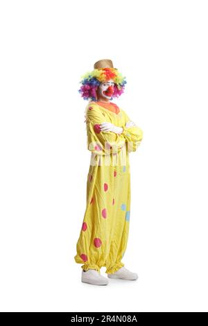 Clown in costume giallo posa con braccia piegate isolate su sfondo bianco Foto Stock