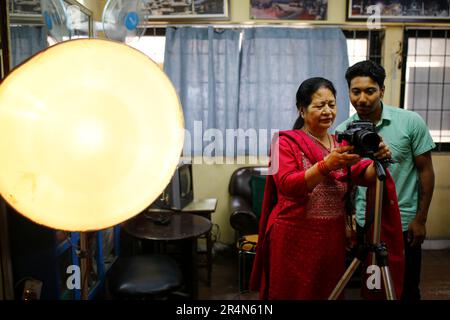 29 maggio 2023, Kathmandu, Nepal: Maiya Shrestha, una donna di 70 anni, Mostra un'immagine al cliente prima di stampare presso Memory Concern in New Road, Nepal, lunedì 29 maggio 2023. Ha imparato le abilità del calcolatore e della stampante all'età di 54. In precedenza, ho lavorato come assistente di banca alla Rastriya Banijya Bank. Dopo che nostro figlio è nato, mio marito ha suggerito che mi unisco a lui nel suo negozio di fotografia. Da allora, ho lavorato in questo campo. In passato, avevamo molti clienti, soprattutto durante festival come Dashain. Tuttavia, in quel momento abbiamo dovuto inviare le foto a Bangkok per lo sviluppo. Più tardi Foto Stock