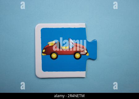 Puzzle di immagine disposti su uno sfondo blu. Auto rossa Foto Stock