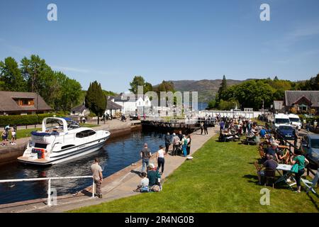 Fort Augustus, Highland, Scozia, Regno Unito, 29 maggio 2023. Il lunedì, durante le festività, vicino alle chiuse del canale di Caledonia, centinaia di turisti che si aggirano e osservano le navi passare attraverso le chiuse. Temperatura 16 gradi centigradi a metà pomeriggio. Nella foto: Kintail 1V passa attraverso le chiuse del canale e infine il ponte oscillante. Foto Stock