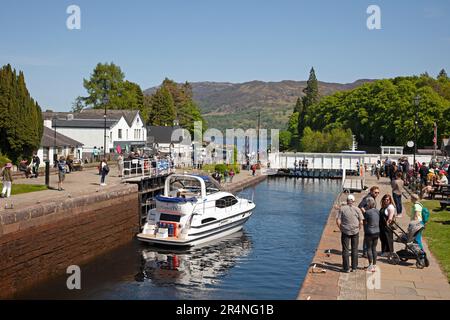 Fort Augustus, Highland, Scozia, Regno Unito, 29 maggio 2023. Il lunedì, durante le festività, vicino alle chiuse del canale di Caledonia, centinaia di turisti che si aggirano e osservano le navi passare attraverso le chiuse. Temperatura 16 gradi centigradi a metà pomeriggio. Nella foto: Kintail 1V passa attraverso le chiuse del canale e infine il ponte oscillante. Foto Stock