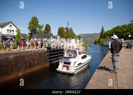 Fort Augustus, Highland, Scozia, Regno Unito, 29 maggio 2023. Il lunedì, durante le festività, vicino alle chiuse del canale di Caledonia, centinaia di turisti che si aggirano e osservano le navi passare attraverso le chiuse. Temperatura 16 gradi centigradi a metà pomeriggio. Nella foto: Kintail 1V passa attraverso le chiuse del canale e infine il ponte oscillante. Foto Stock