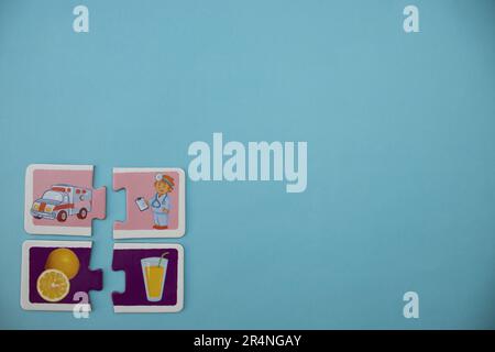 Puzzle di immagine posti sul bordo dello sfondo blu. Arancia tagliata, succo, ambulanza e medico. Foto Stock