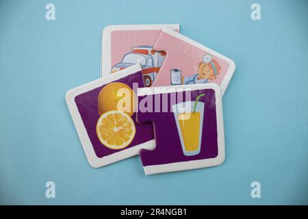 Puzzle di immagine disposti su uno sfondo blu. Arancia tagliata, succo, ambulanza e medico. Misto. Foto Stock