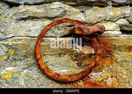Olberg; Olbergstranden; Raege; Norvegia; maggio 20 2023, Un vecchio anello d'ormeggio per barche da pesca arrugginite fissato nella roccia naturale del Muro del Porto Foto Stock