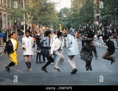 Block party a Brooklyn NY con un gruppo di bambini che saltano la corda e si allestiscono per il doppio olandese. Foto Stock