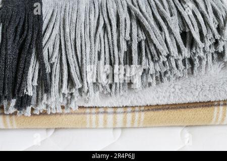 Tre coperte: Grigio e beige sul materasso. Risorse grafiche Foto Stock