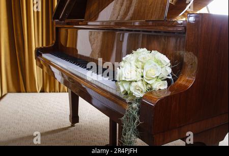 Bouquet di rose bianche che si stenderà sulle chiavi del pianoforte. Decorazioni per feste Foto Stock