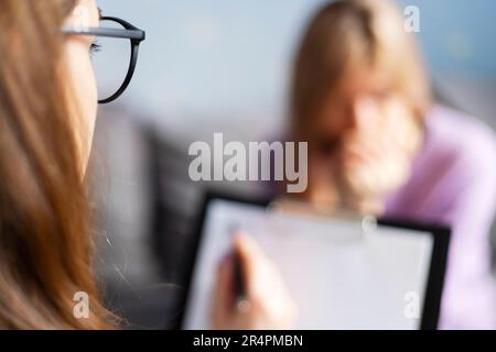 Sessione di psicoterapia, una donna sta parlando con la sua psicologa in ufficio accogliente Foto Stock