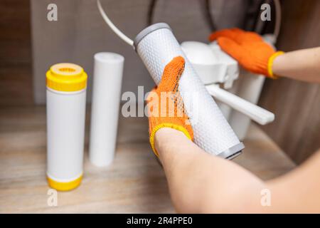 L'idraulico installa o cambia il filtro dell'acqua. Filtro acqua di ricambio Foto Stock