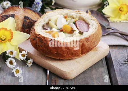 La zuppa di segale acida all'interno del pane. Tavolo per la colazione di Pasqua. Periodo festivo Foto Stock