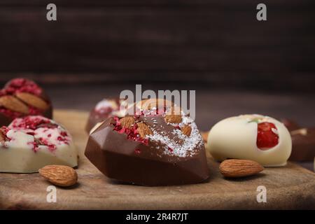 Gustose caramelle al cioccolato a forma di cuore con noci, primo piano Foto Stock