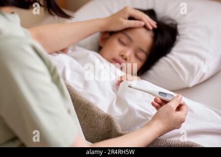 Bambino giapponese ammalato a letto Foto Stock