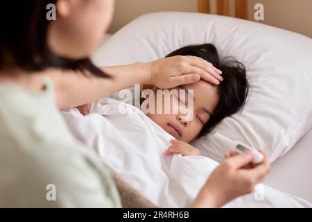 Bambino giapponese ammalato a letto Foto Stock