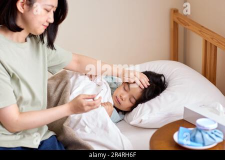 Bambino giapponese ammalato a letto Foto Stock