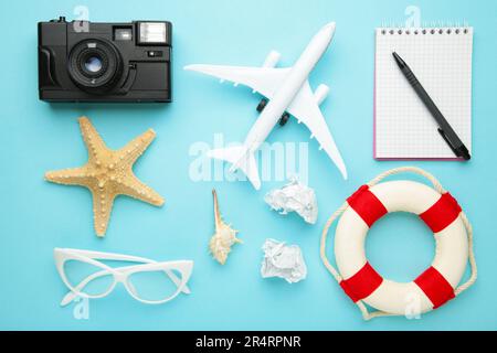 Pianificazione vacanze estive, turismo e viaggio vintage sfondo. Notebook da viaggio con accessori blu. Foto Stock