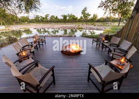 Campfire presso la buca d'acqua al campo forestale di Onguma, Riserva di gioco di Onguma, Namibia, Africa Foto Stock
