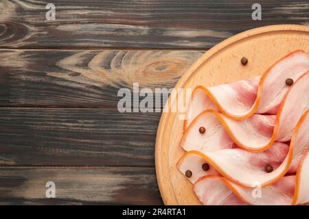 Pancetta fresca e fredda affettata sul tagliere di legno. Vista dall'alto. Foto Stock