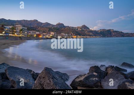 Vista delle città collinari di Castelmola e Taormina al crepuscolo, Provincia di Messina, Sicilia, Italia, Mediterraneo, Europa Foto Stock