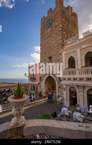 Vista sulla Torre dell'orologio e porta di mezzo e sulla strada trafficata di Taormina, Taormina, Sicilia, Italia, Europa Foto Stock